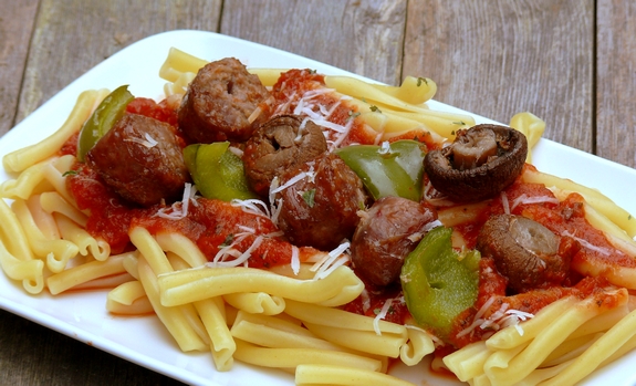 These deliciously grilled Sausage Kabobs served with Pasta are a fun and easy dinner to prepare. They are especially loved by kids. Sausage kabobs sitting on top of pasta.