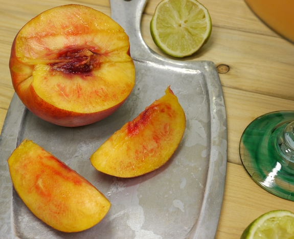 This stone cold, top shelf frozen margarita recipe using frozen nectarines is one for the books. Nectarine-Basil Frozen Margaritas are going to be your new favorite. Sliced nectarine on a tray.