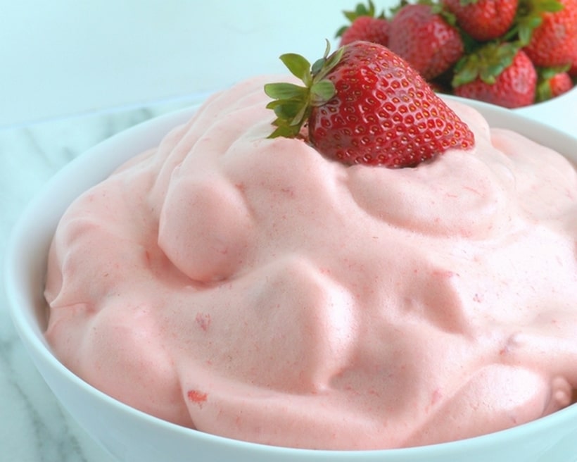 Bowl of strawberry mousse with strawberries on top.