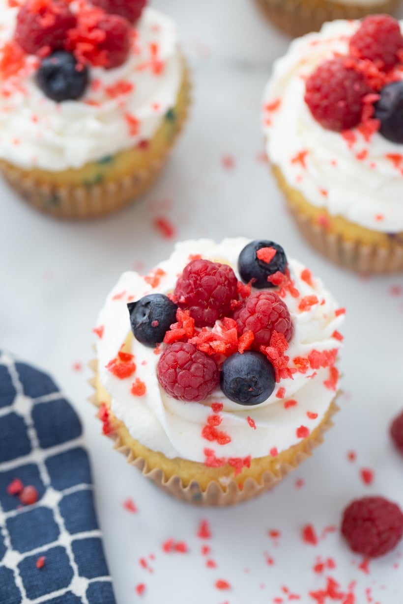 Firework cupcake topped with whipped cream, raspberries, blueberries, and Pop Rocks.