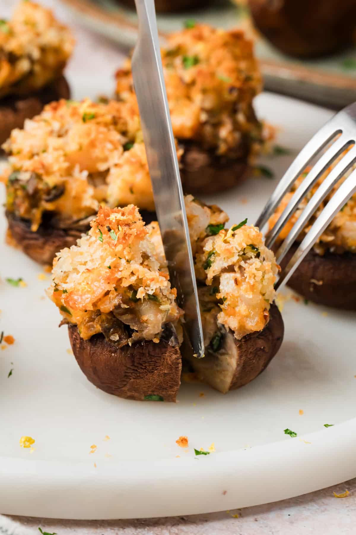 Shrimp stuffed mushroom cut open to show the shrimp, cream cheese and mushroom filling