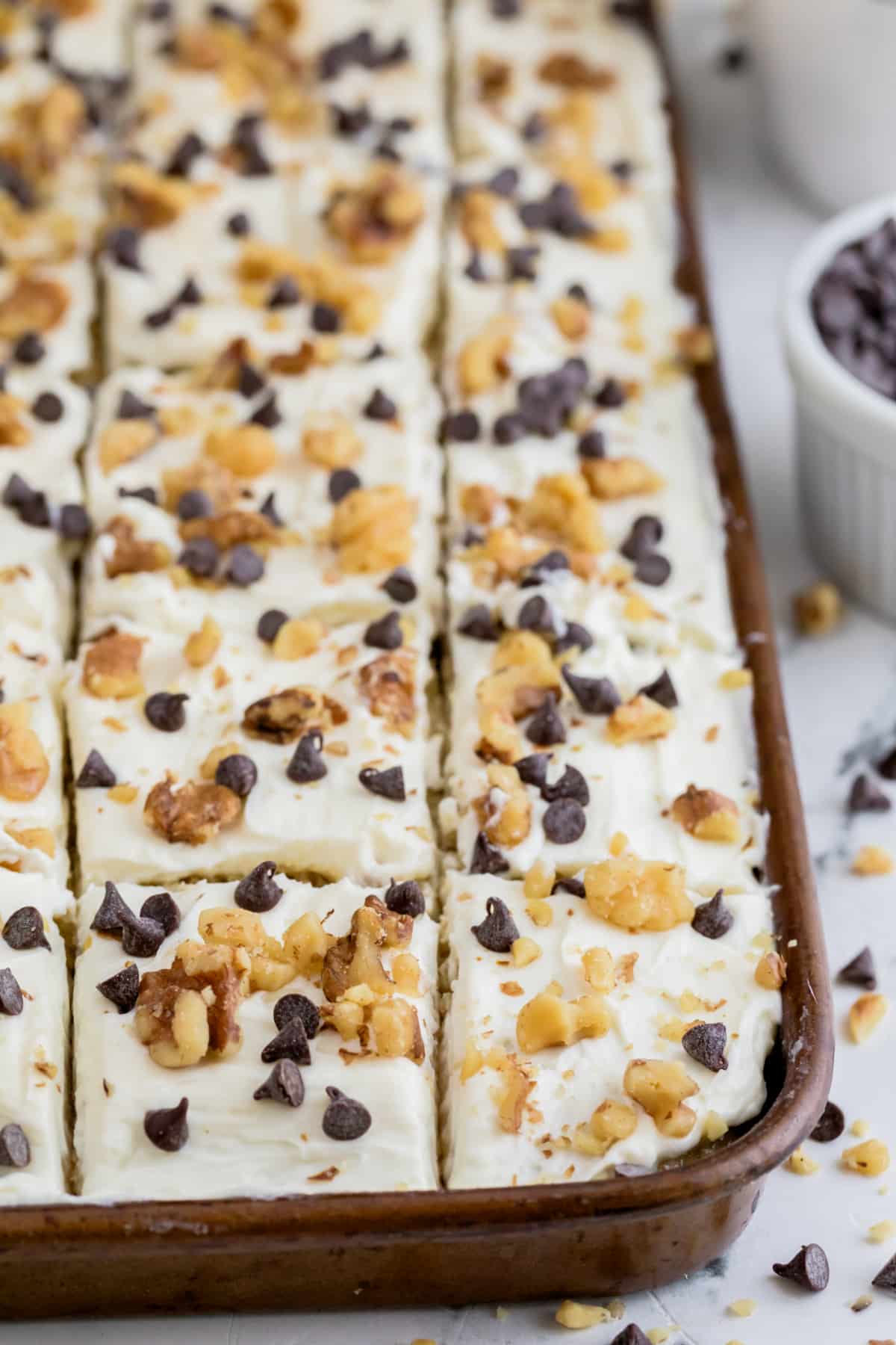 Banana Sheet Cake with Cream Cheese Sour Cream Frosting in the pan Banana sheet cake in a sheet pan with slice lines scored across the top.