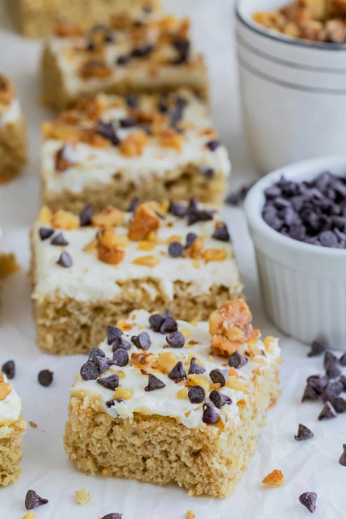 slices of Banana Sheet Cake with Cream Cheese Sour Cream Frosting Side angle showing several slices of banana sheet cake with frosting stacked or lined up.