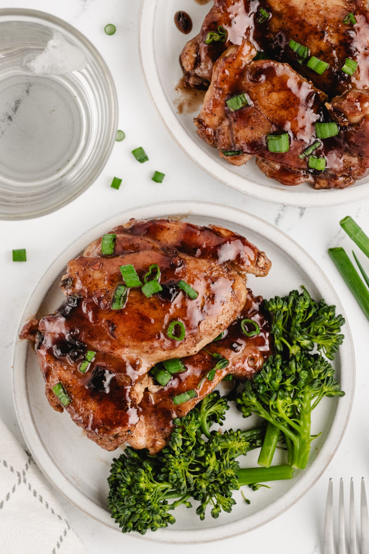 Saucy Plum Chicken on a plate Overhead shot of saucy plum chicken served with broccoli on a white plate, coated in a glossy plum sauce.