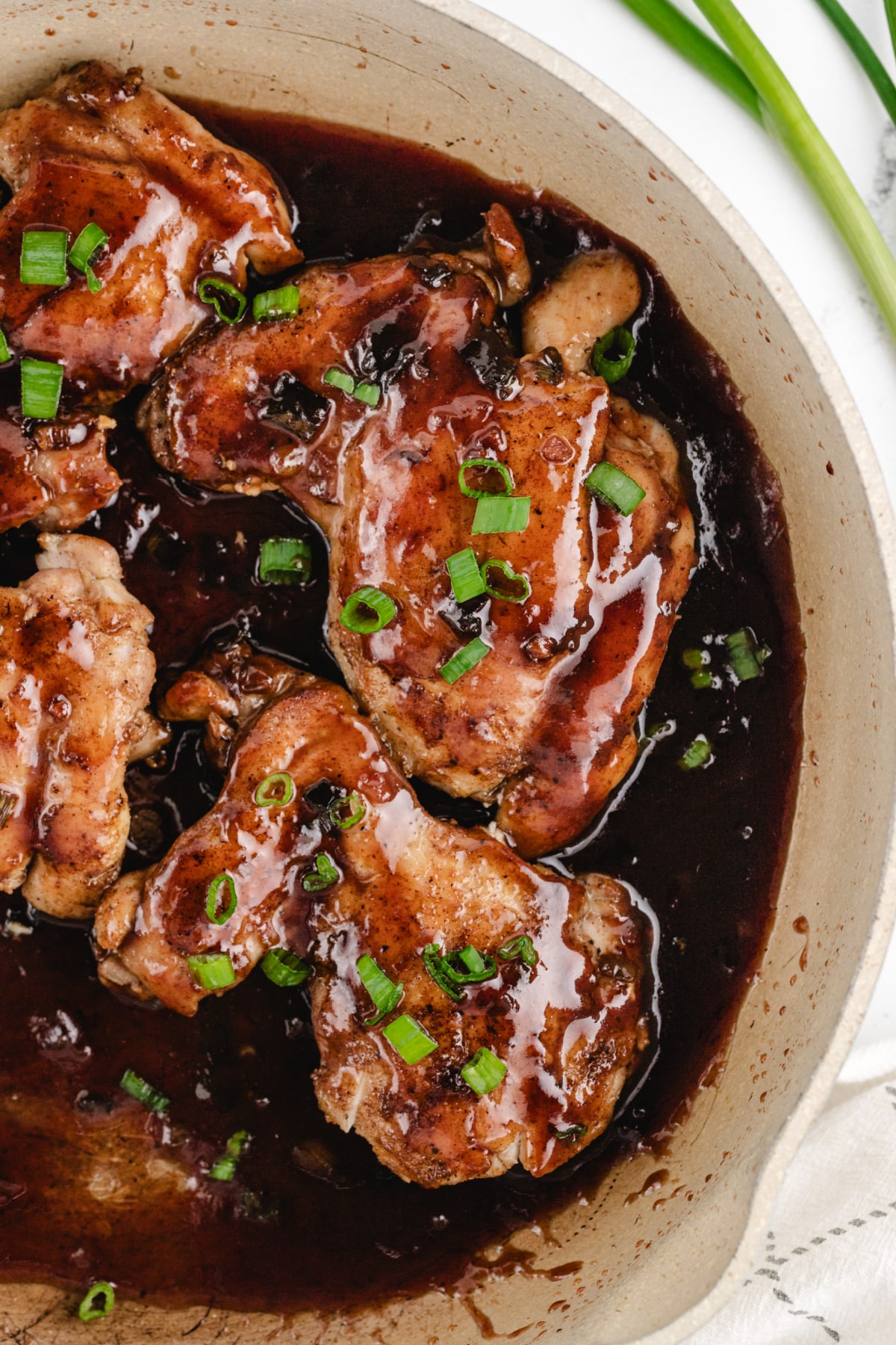Saucy Plum Chicken finished in the skillet Close-up overhead shot of the plated saucy plum chicken and broccoli, showing the caramelized exterior and thick sauce.