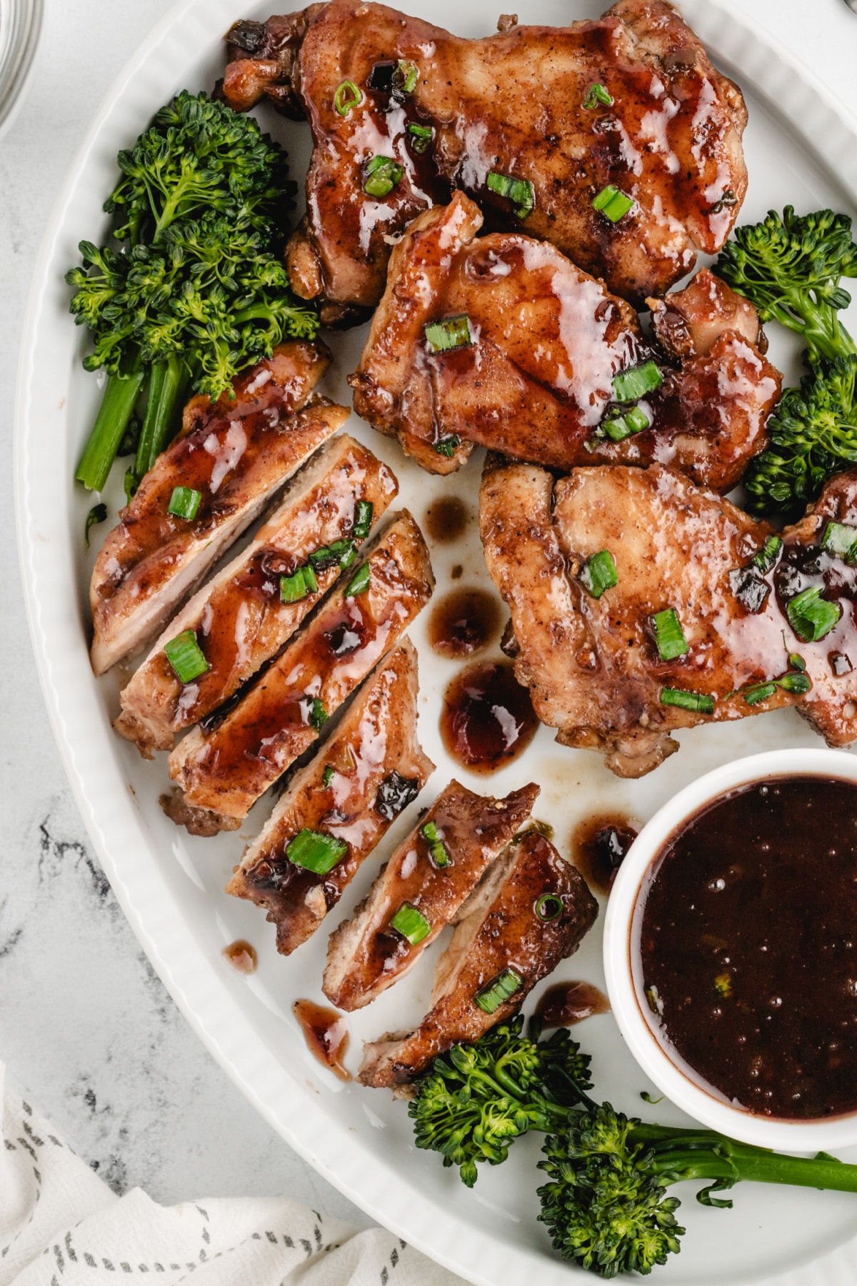 Saucy Plum Chicken sliced on a platter Saucy plum chicken arranged on a serving platter, with some pieces sliced to reveal the juicy interior and thick glaze.