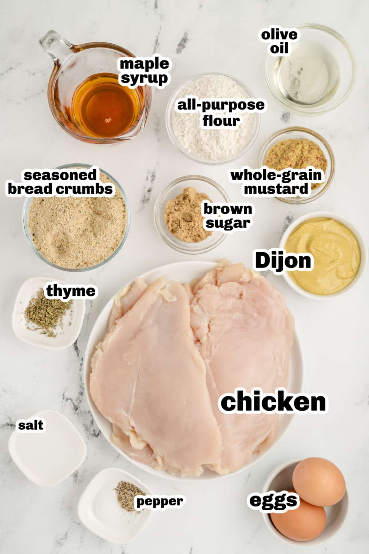 Ingredients for making maple mustard glazed chicken cutlets laid out on a white surface