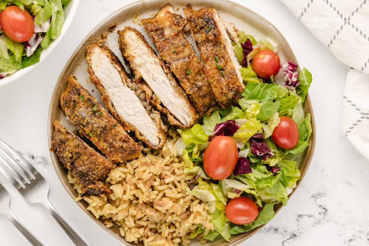 Plate of crispy baked chicken cutlets coated in maple mustard glaze