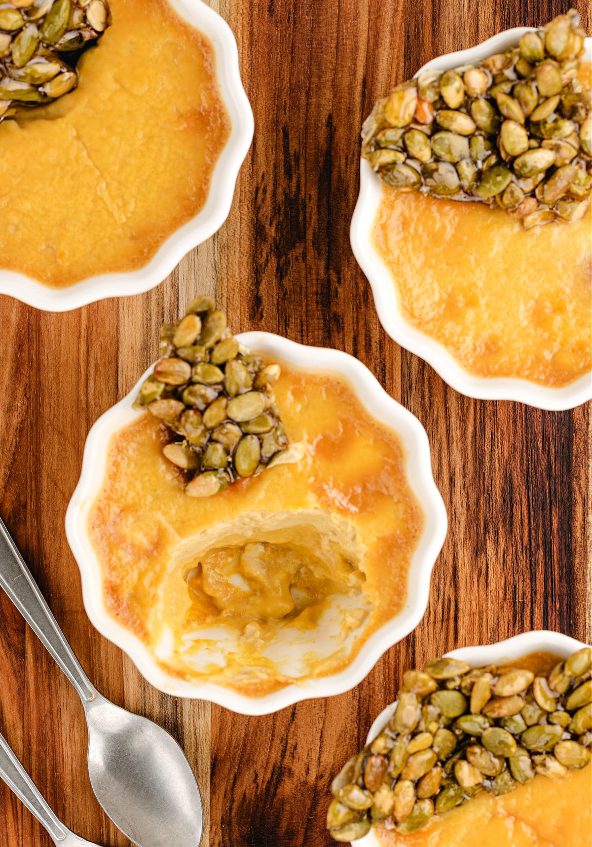 inside pumpkin chai pots de creme Pumpkin Chai Pots de Crème with a spoonful taken out to show the creamy chai-spiced pumpkin custard beneath the brittle topping.
