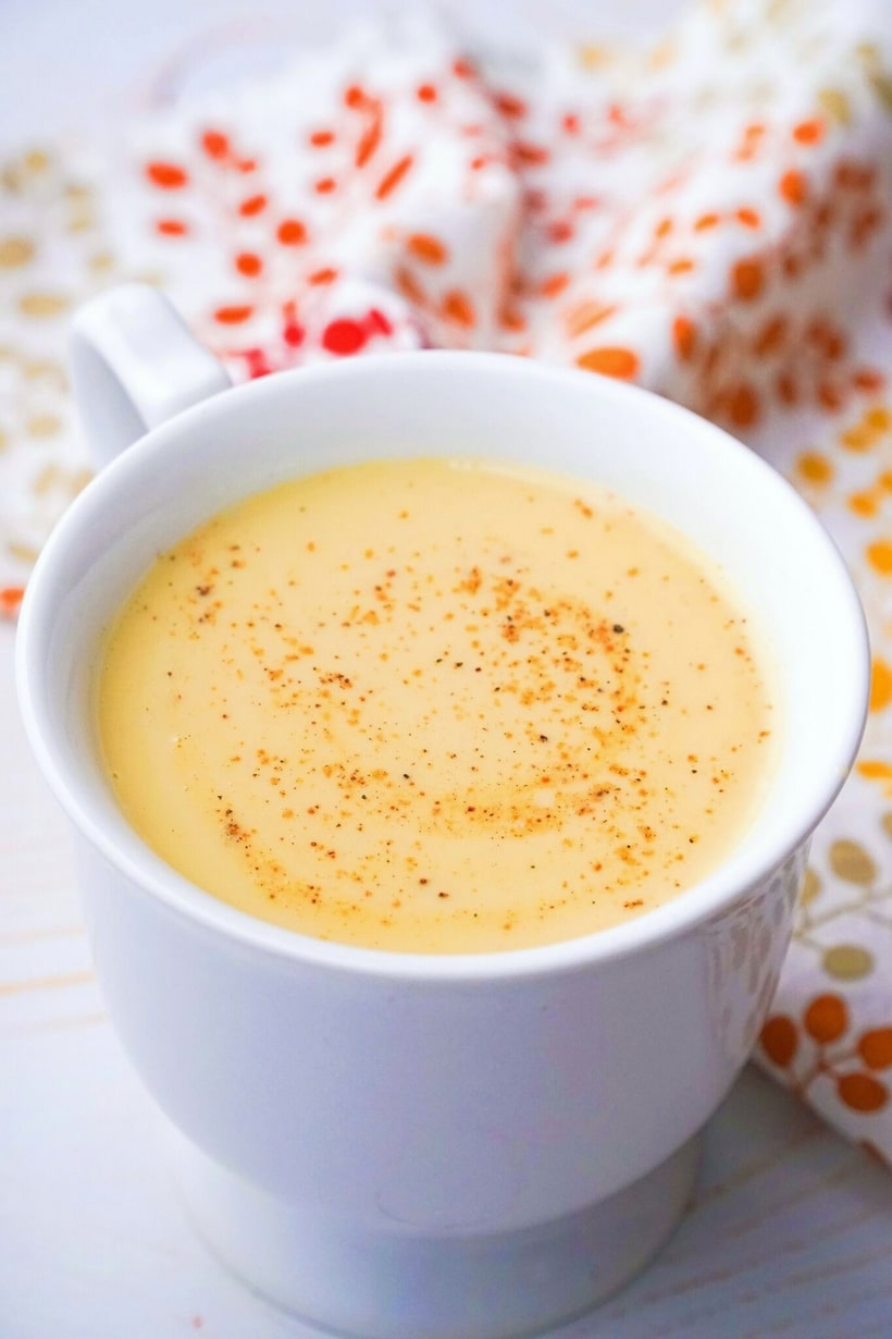 Creamy Chai Eggnog served in a white mug with a sprinkle of nutmeg on top.