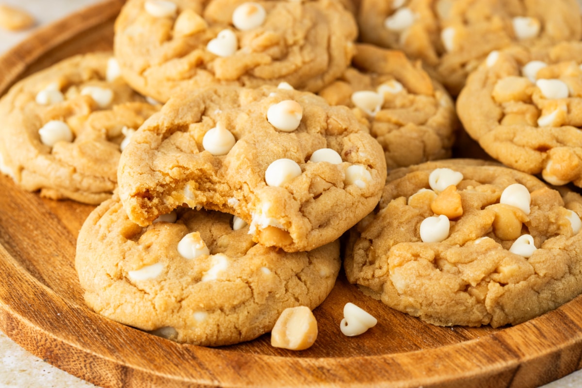 White Chocolate Macadamia Nut Cookies with Soft Center white chocolate macadamia nut cookies with a soft center and a bite showing white chocolate chips and macadamia nuts