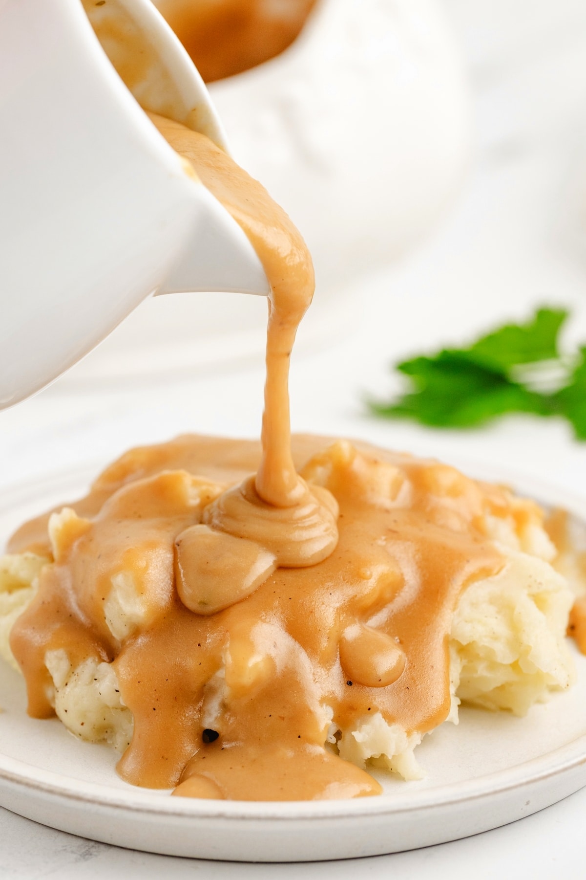 Make Ahead Turkey Gravy Poured Over Mashed Potatoes Silky make ahead turkey gravy for Noble Pig made from roasted turkey wings, poured over fluffy mashed potatoes. Smooth, golden brown, and perfect for Thanksgiving dinner.