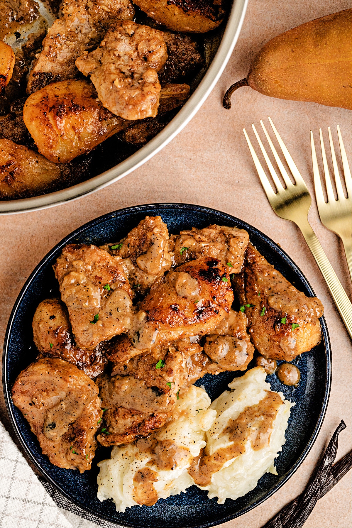 Vanilla Cider Pork with caramelized Pears served on a plate with mashed potatoes, showing tender pork with pears coated in cider-cream sauce.