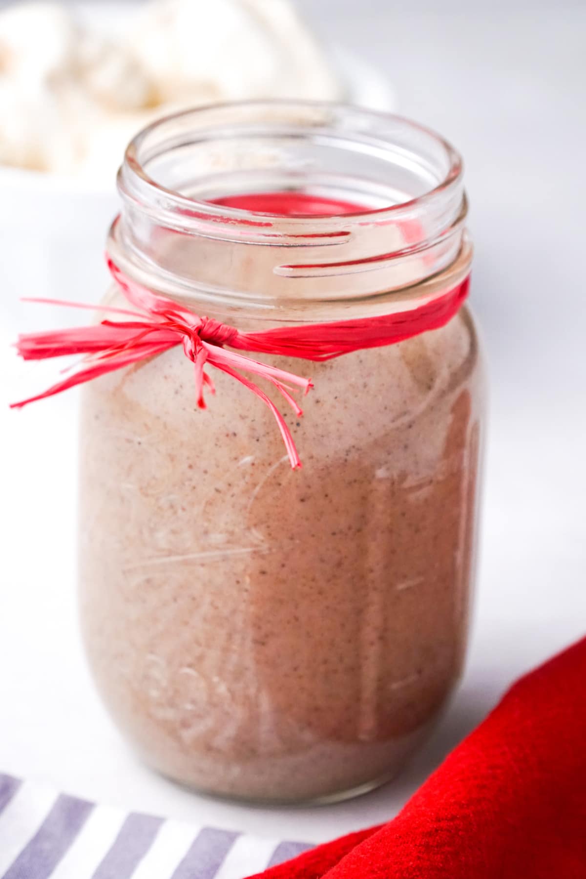 Jar of homemade chai-spiced syrup tied with a red ribbon