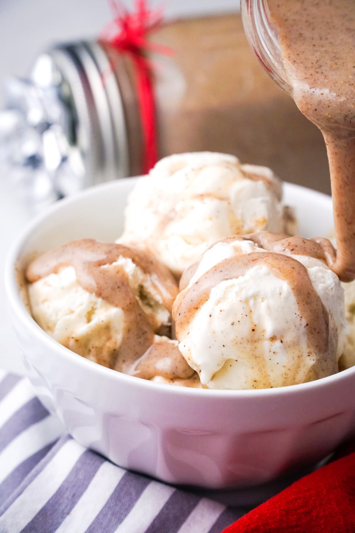 Chai syrup being poured over scoops of vanilla ice cream