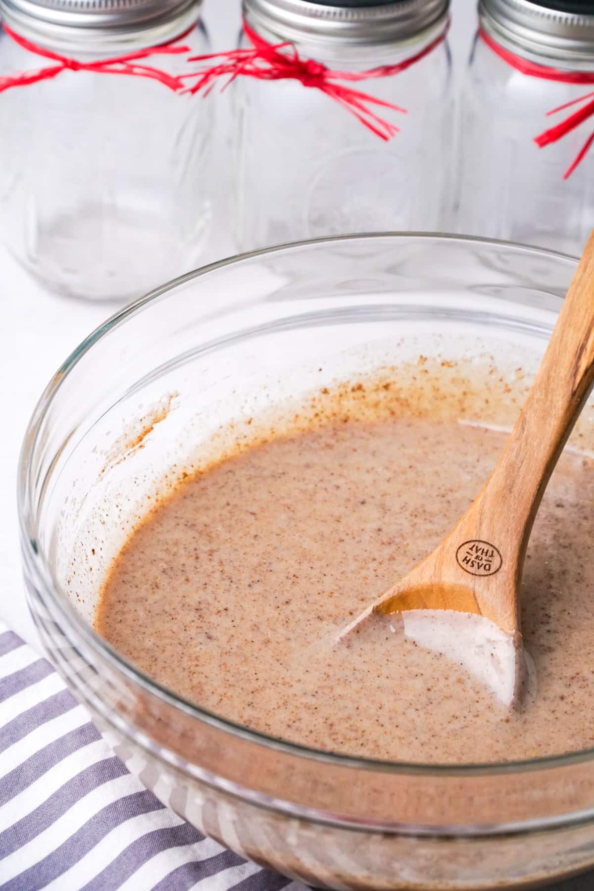 Glass bowl with wooden spoon mixing chai syrup