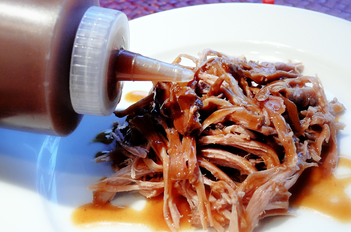 Carolina-style brown sugar vinegar BBQ sauce poured over pulled pork, tangy vinegar-based BBQ sauce with butter, molasses, and brown sugar. 