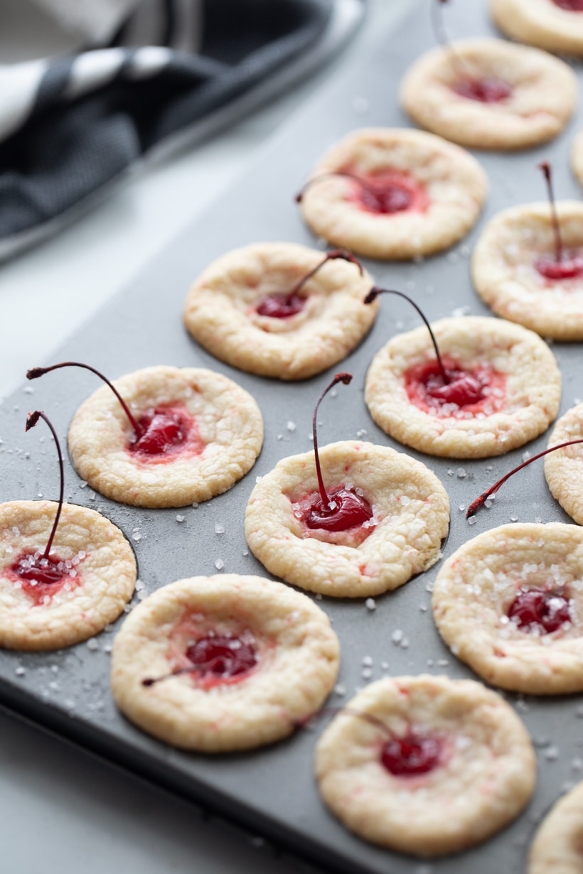 Long stemmed maraschino cherries burst right out the top of these pillowy-soft and bite-sized pastry pouch cookies. They are the perfect addition to any dessert table. pastry pouch cookie