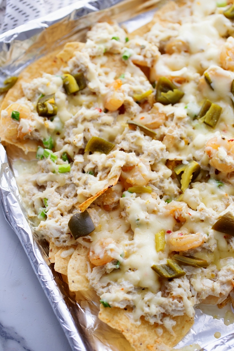 Enhancing the traditional combo of tortilla chips, melted cheese, and pickled jalapenos with shrimp and crab gives these Seafood Nachos a unique flair. They're not just a great pre-dinner but; they can also hold their own as a substantial meal if needed. This loaded seafood nachos recipe is easy to make and makes great party food. shrimp and crab nachos