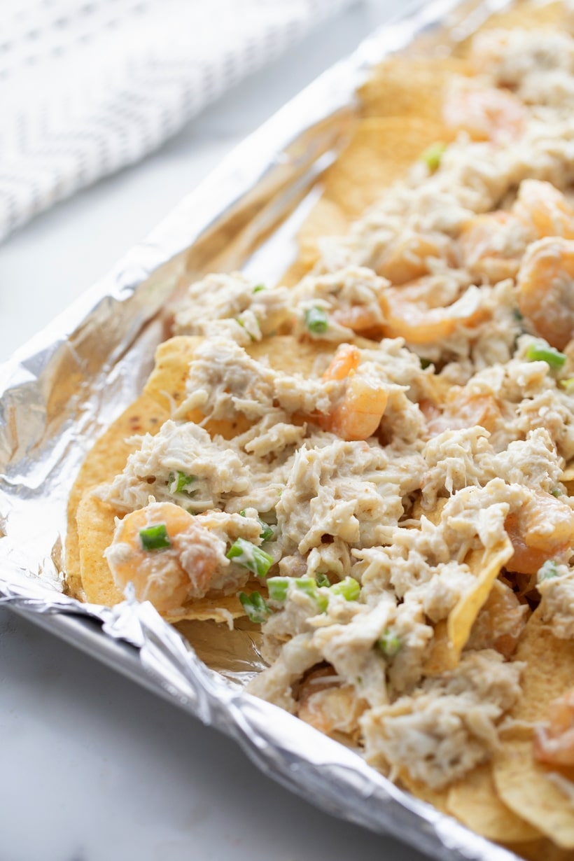 Enhancing the traditional combo of tortilla chips, melted cheese, and pickled jalapenos with shrimp and crab gives these Seafood Nachos a unique flair. They're not just a great pre-dinner but; they can also hold their own as a substantial meal if needed. This loaded seafood nachos recipe is easy to make and makes great party food. seafood nachos