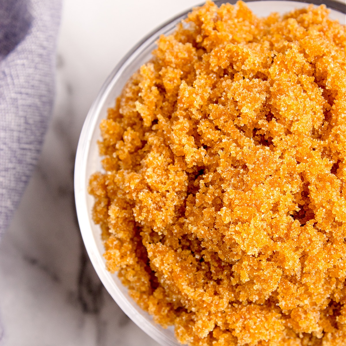 A close-up overhead view of homemade brown sugar in a bowl, showing the grainy caramel-colored crystals.