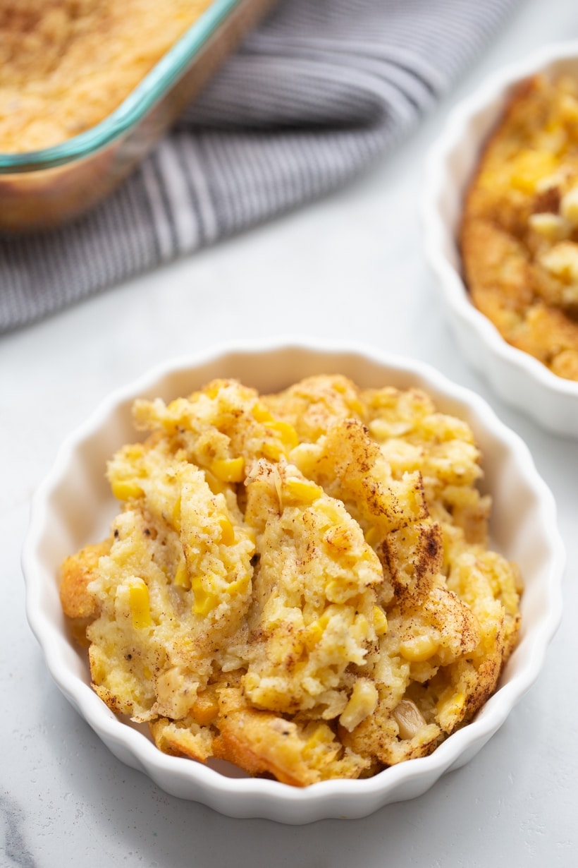 Close-up shot of corn pudding in a fluted ramekin, capturing the soft, custardy center.