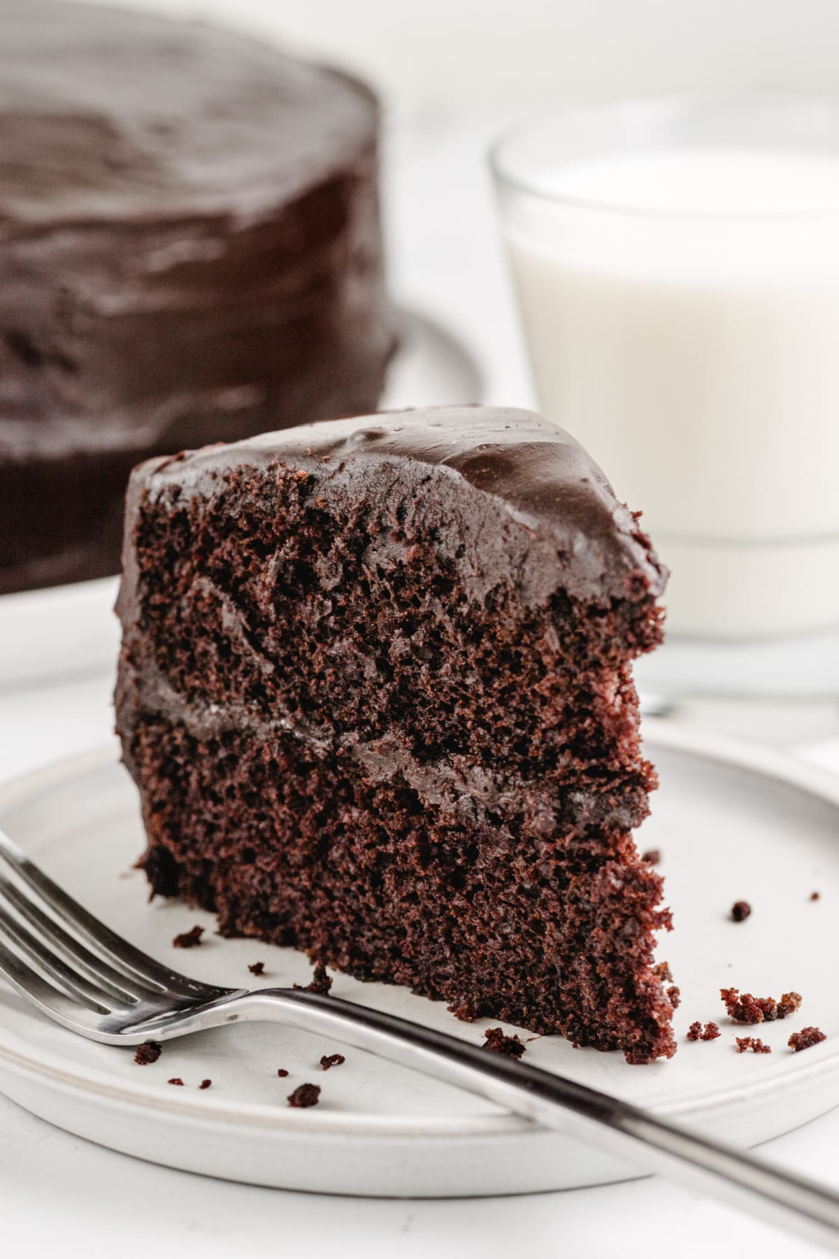 a slice of chocolate cake on a plate with a bite taken out, showing the rich chocolate color.