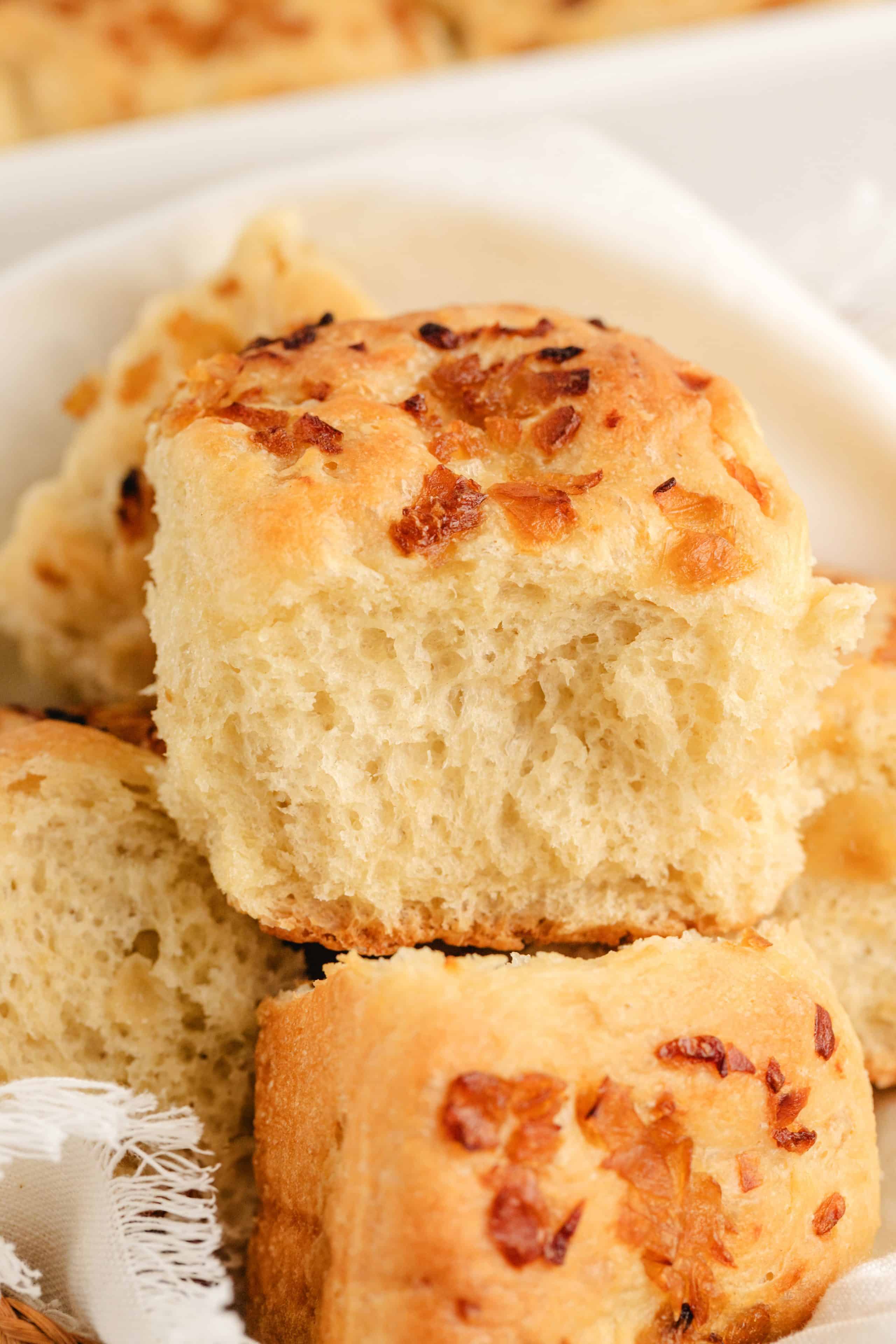 No-Knead Onion Rolls in a pile A close-up of onion rolls stacked together, highlighting their airy texture and rich onion flavor.