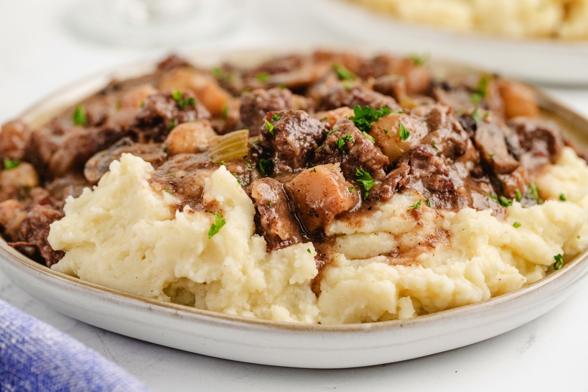 Beef Bourguignon close-up side view of Beef Bourguignon on potatoes