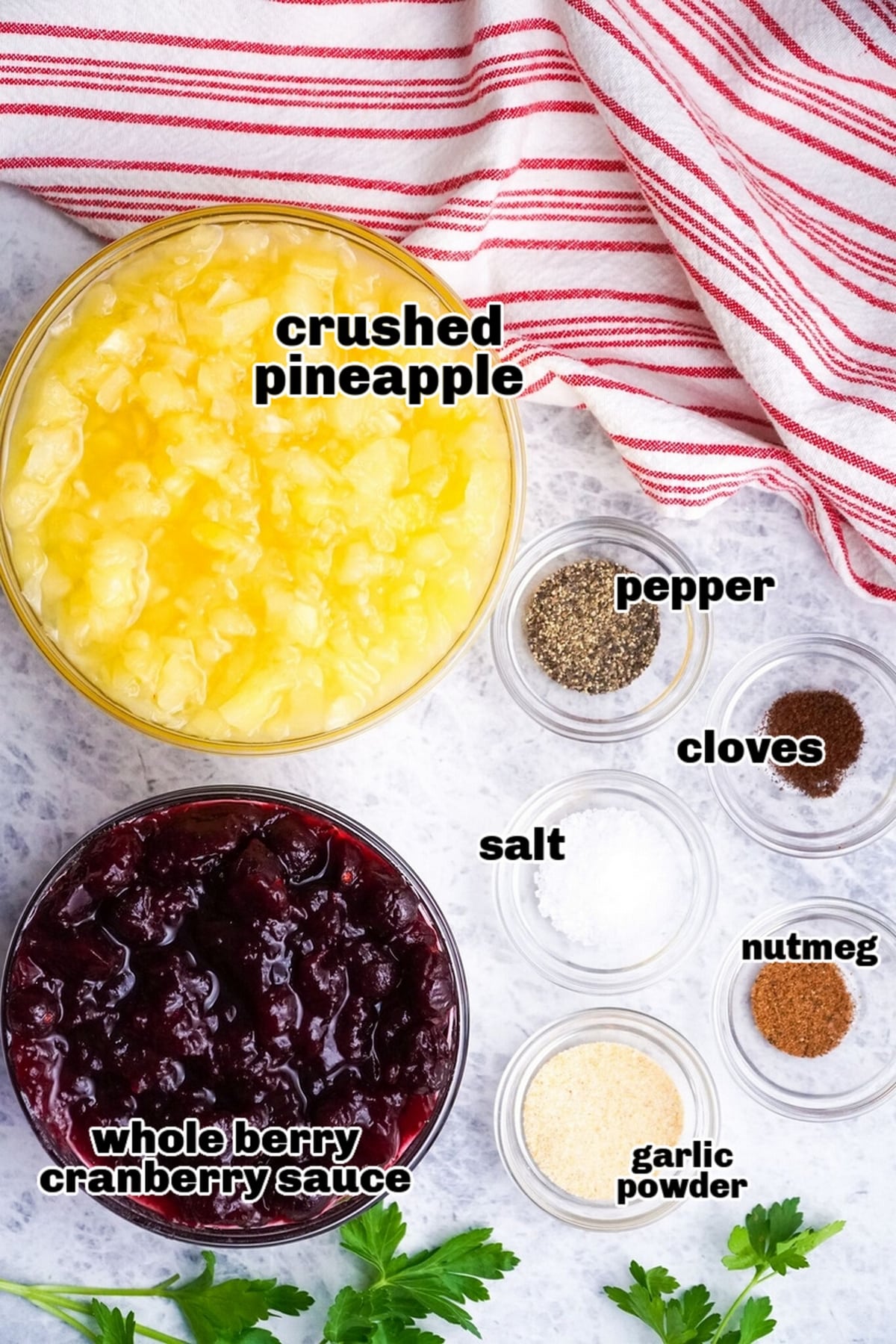 Ingredients for making pork, including pork loin, cranberry sauce, pineapple, and spices, arranged on a countertop.