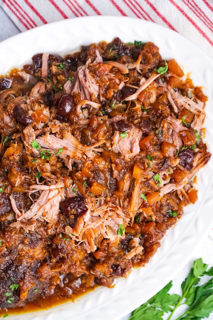Detailed close-up of pork with cranberry-pineapple sauce on top.