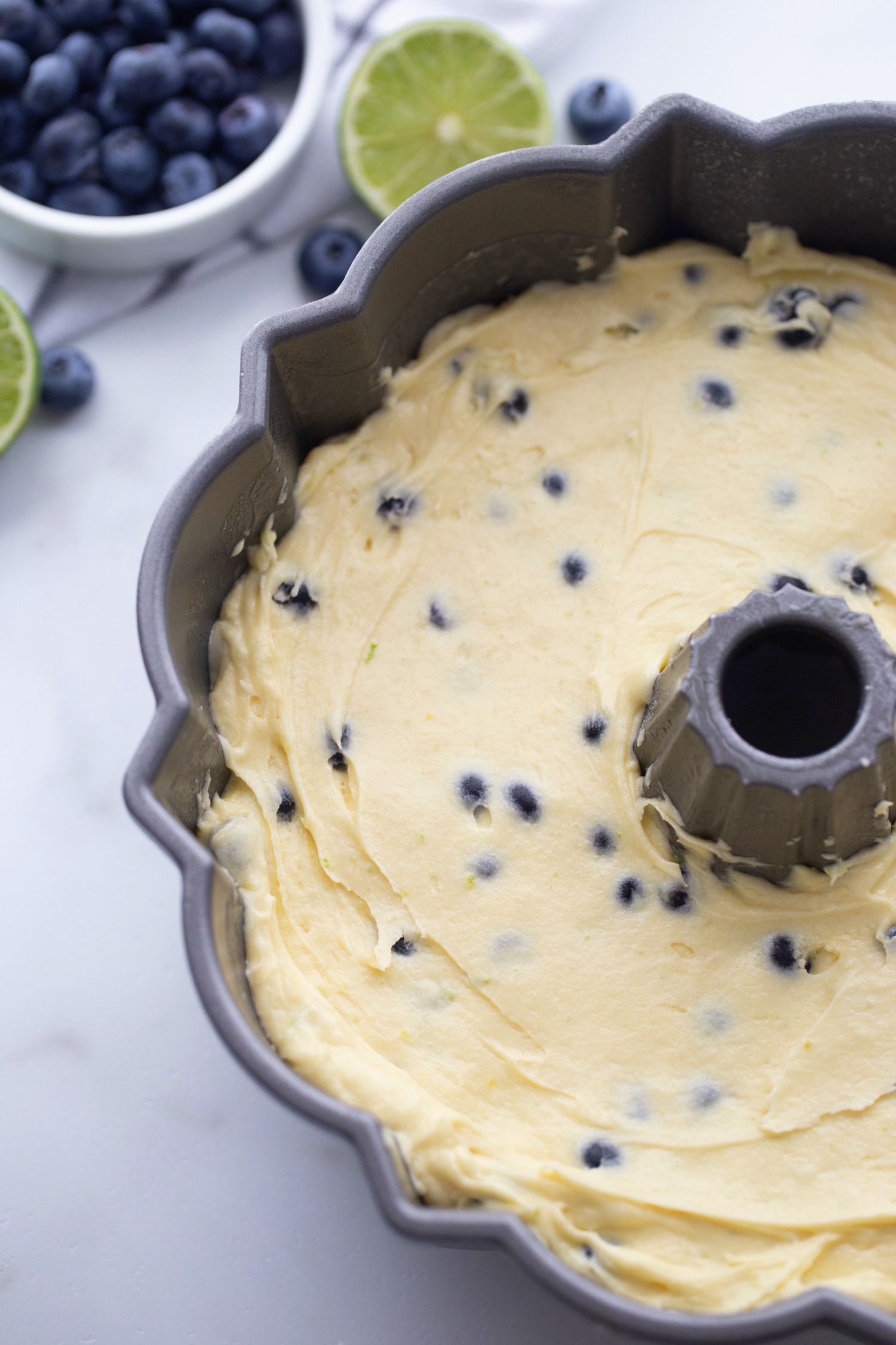 Overhead view of smooth batter evenly spread in a floured Bundt pan, ready to bake.