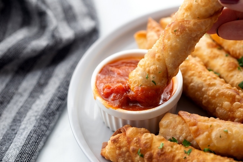 Mozzarella Pepperoni Pizza Sticks made with egg roll wrappers are crunchy on the outside with gooey cheese and pepperoni on the inside. These are a fun appetizer for any party. pizza with mozzarella sticks