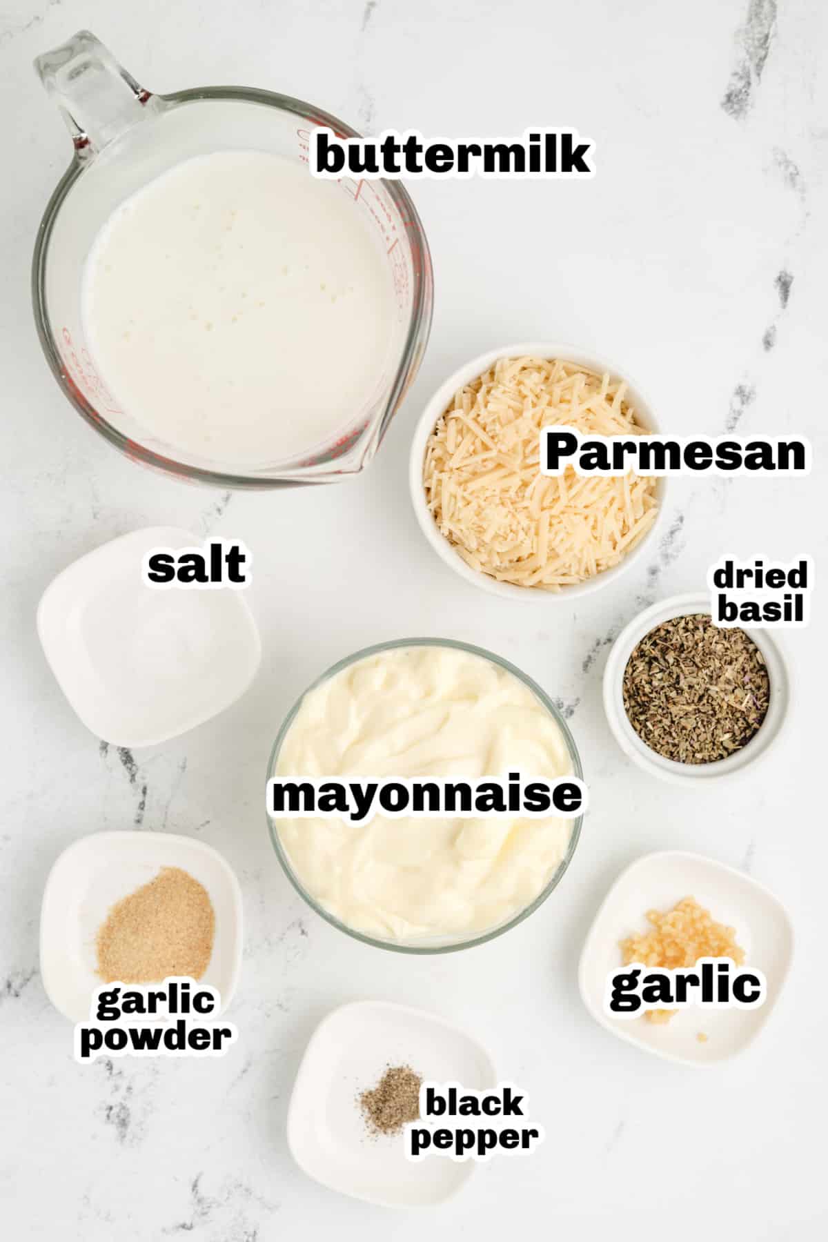 Ingredients for creamy pesto dressing recipe including mayo, buttermilk, basil, garlic, and Parmesan