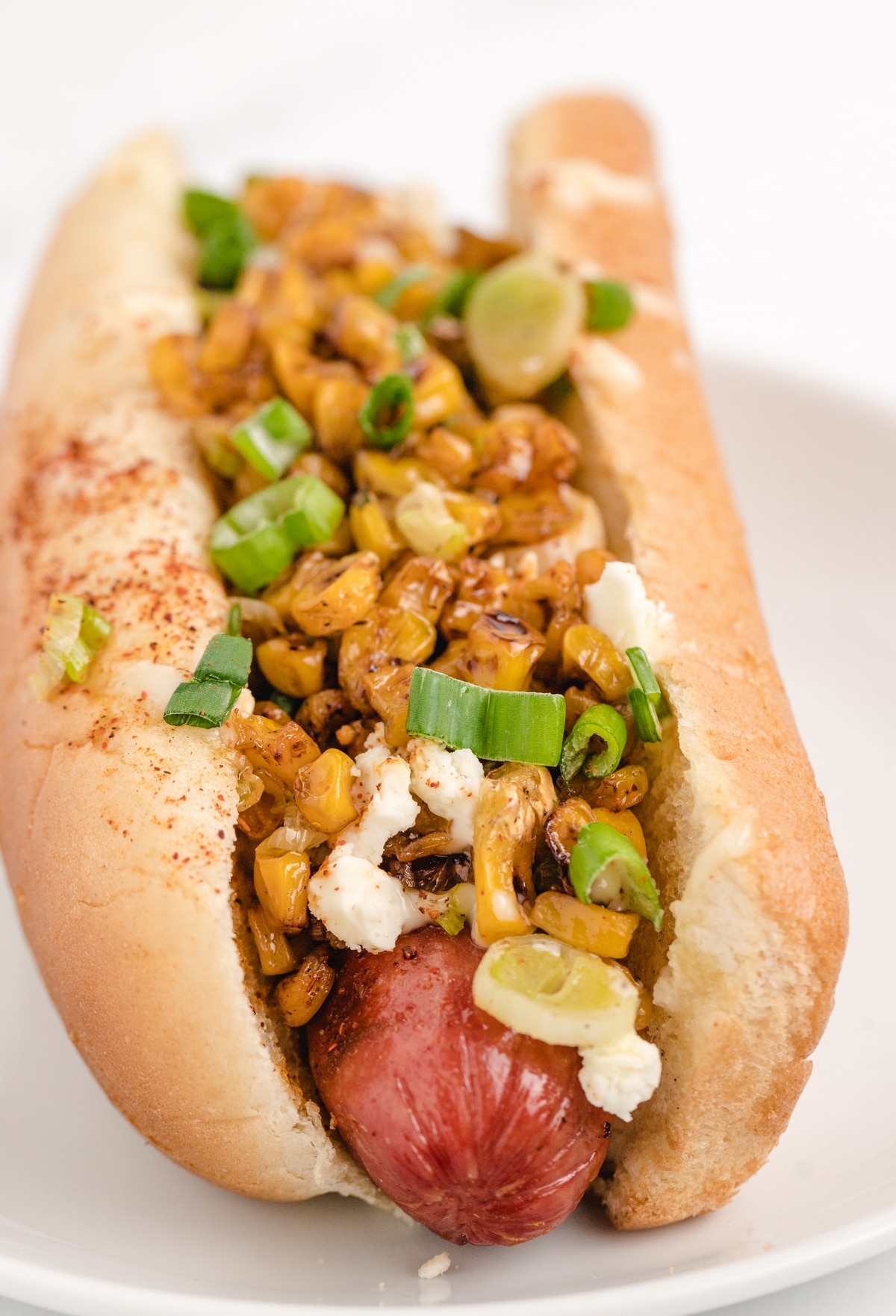 Corn and onions make up the base while a lime mayonnaise and Cotija cheese top it off. elote dog