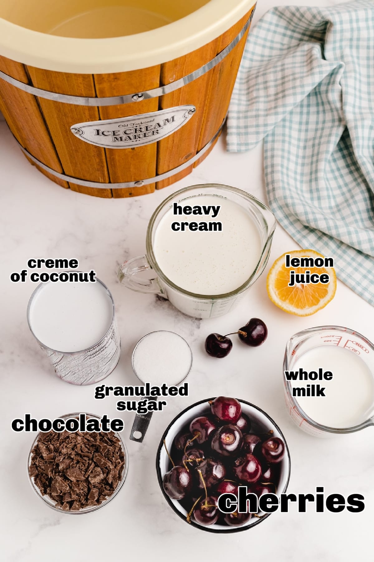 Ingredients for Cherry Coconut Chocolate Chip Ice Cream Overhead view of labeled ingredients for cherry coconut chocolate chip ice cream, including cherries, crème of coconut, and chopped chocolate.