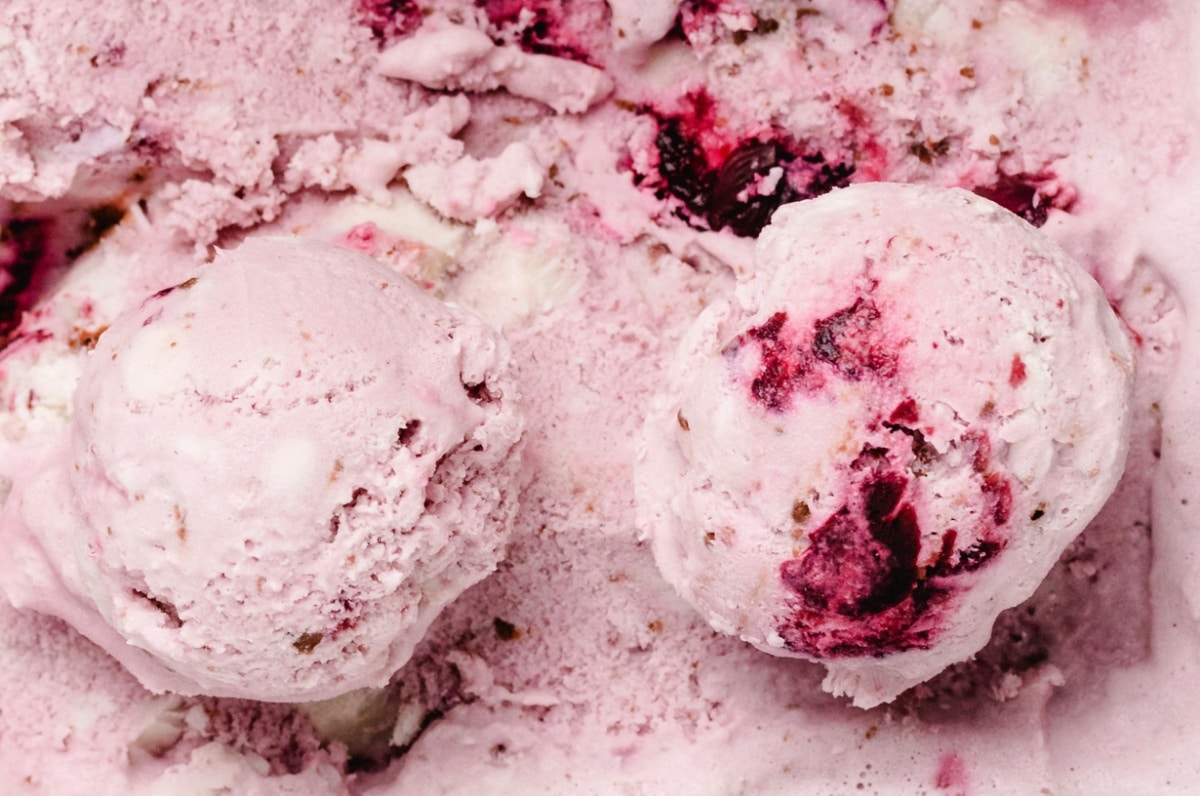 Close-Up of Cherry Coconut Chocolate Chip Ice Cream Close-up of two scoops of cherry coconut chocolate chip ice cream showing the real fruit pieces and rich creamy texture.