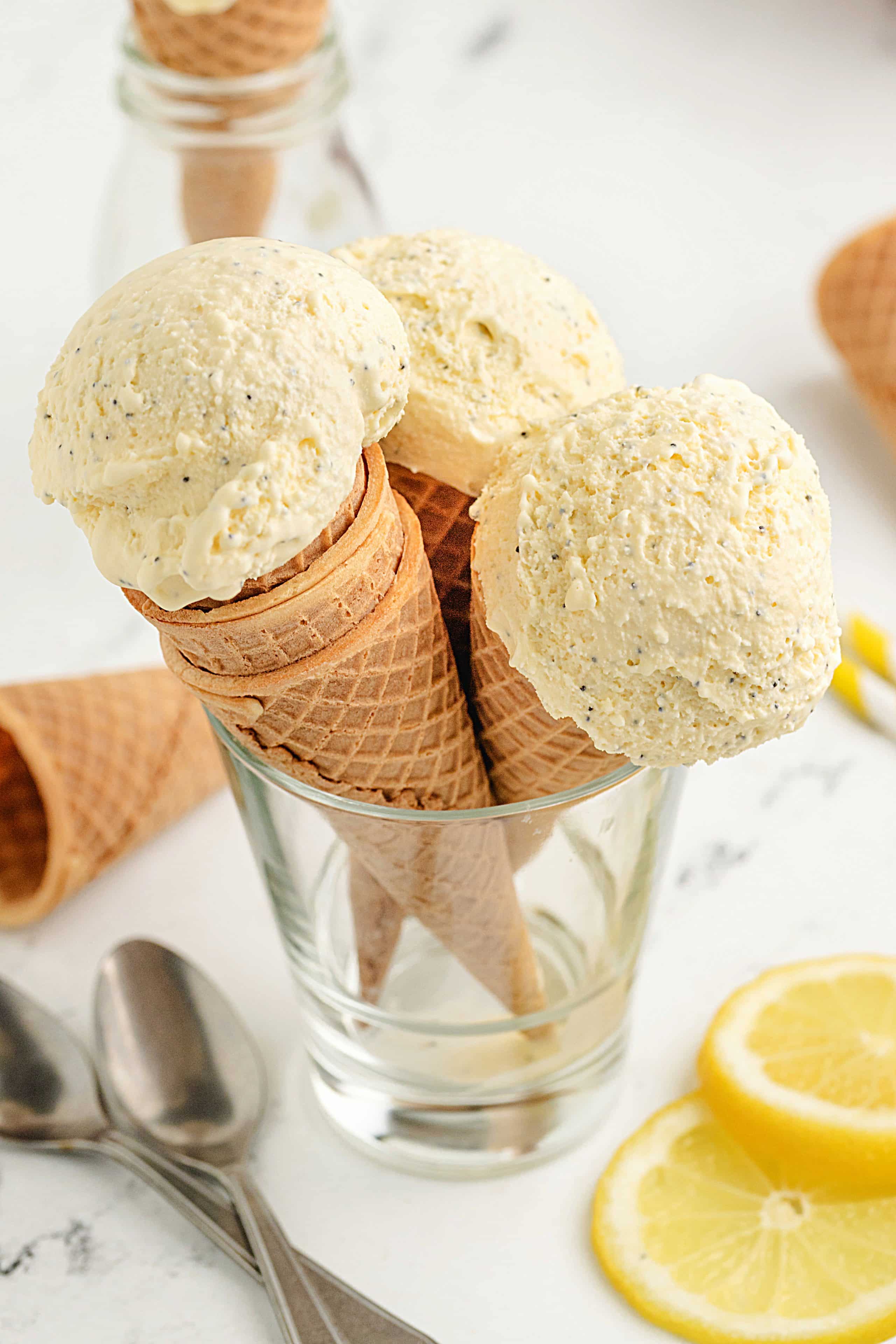 Homemade Lemon Poppy Seed Ice Cream in Waffle Cones Waffle cones filled with scoops of homemade lemon poppy seed ice cream in a glass