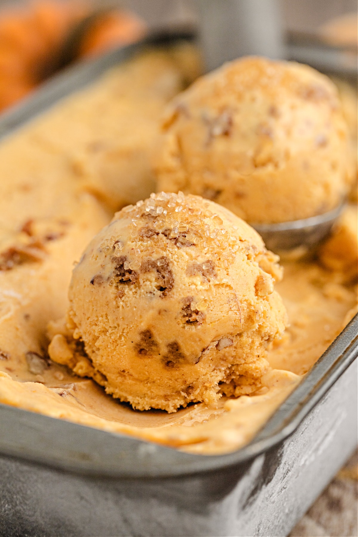 Pumpkin Brown Sugar Crunch Ice Cream by Noble Pig Close-up of Pumpkin Brown Sugar Crunch Ice Cream by Noble Pig, showing creamy scoops studded with pecan streusel and sprinkled with turbinado sugar for sparkle.