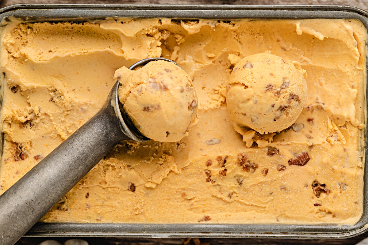 Pumpkin Brown Sugar Crunch Ice Cream by Noble Pig Pumpkin Brown Sugar Crunch Ice Cream by Noble Pig in a metal pan, showing creamy custard texture with baked pecan streusel folded through for a buttery crunch.