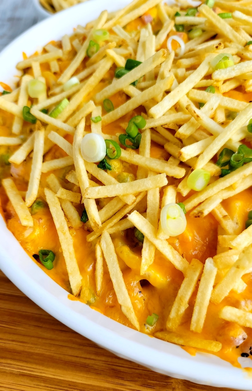 Ham and Cheese Casserole with Crunchy Topping close up Close-up detail of the casserole topped with melted cheddar and chopped scallions for garnish.