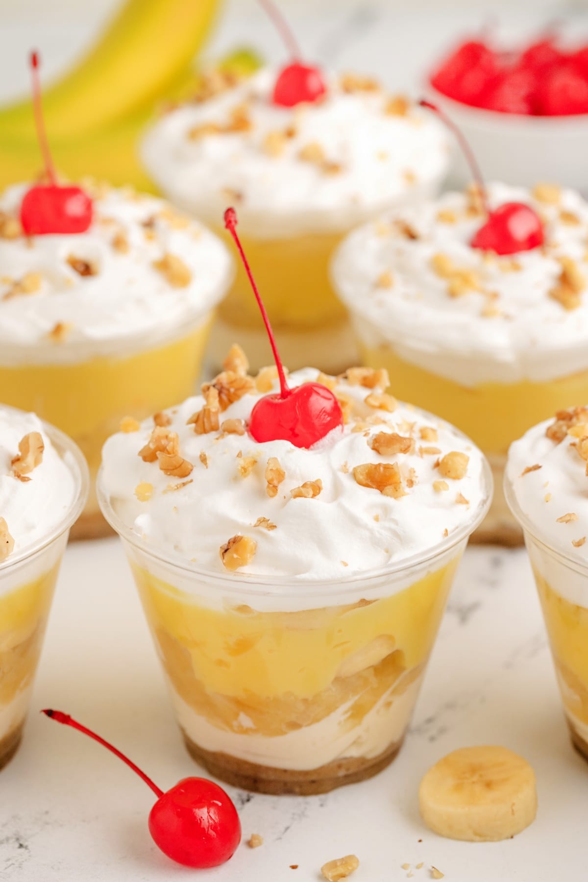 These No-Bake Banana Split "Cakes" are streamlined into cute, individual portions. Perfect for your next gathering—easy to serve, no oven needed, and just the right amount of sweetness. no bake banana split cakes