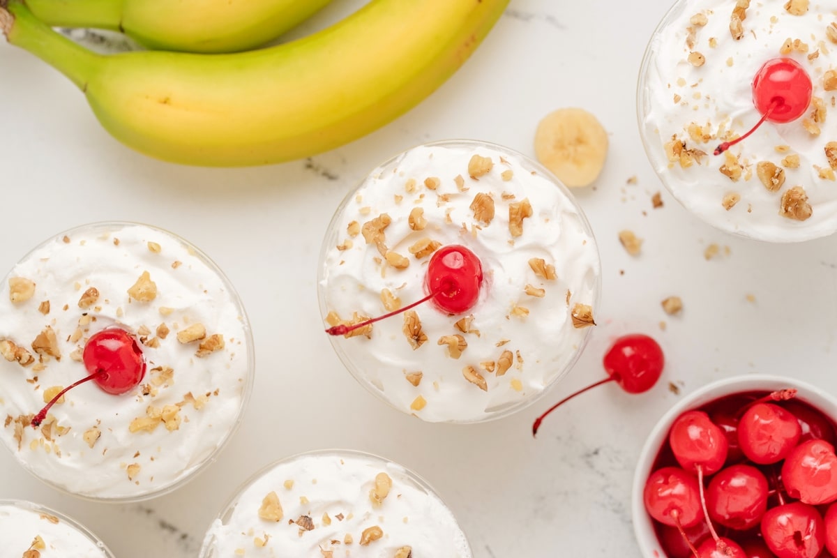 These No-Bake Banana Split "Cakes" are streamlined into cute, individual portions. Perfect for your next gathering—easy to serve, no oven needed, and just the right amount of sweetness. recipe for no bake banana split cake