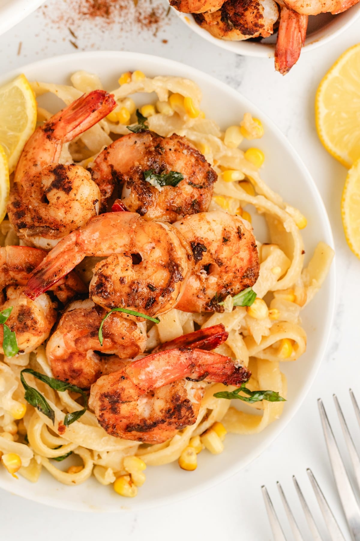 Close-up of shrimp and corn fettuccine with fresh basil.