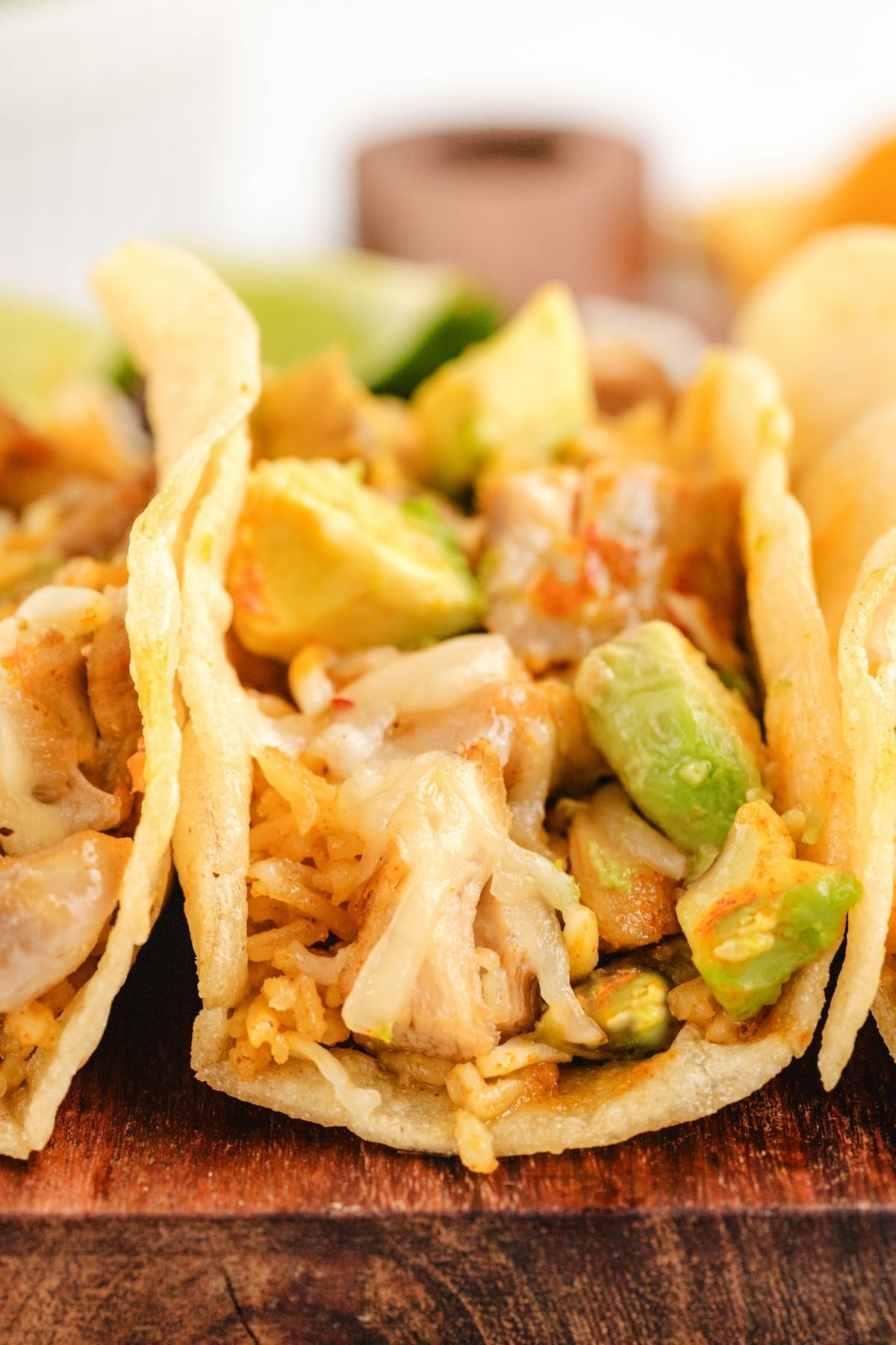 Chicken Paprikash Tacos on a cutting board A bite taken out of a Chicken Paprikash Taco, revealing the tender chicken, cheese, and avocado inside.