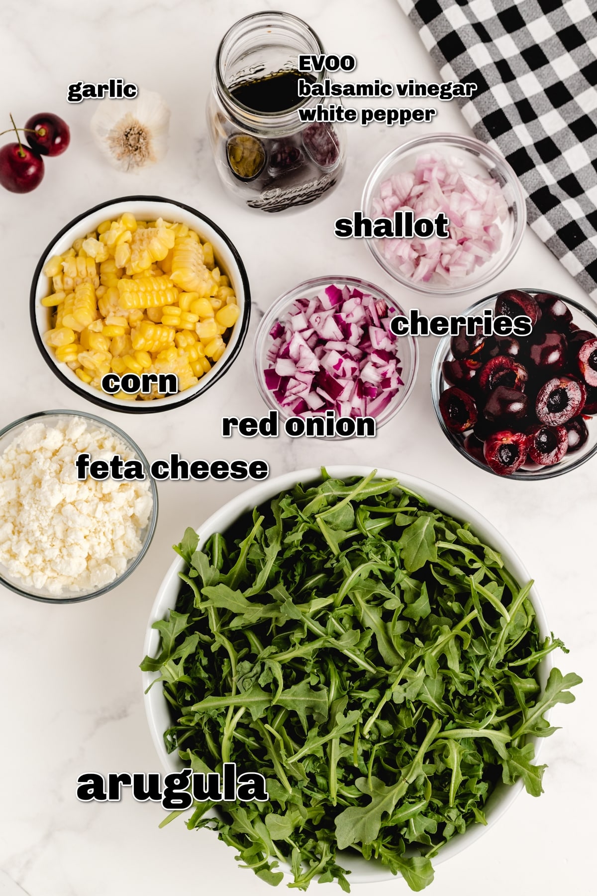 cherry salad prep with corn, cherries, and vinaigrette Clean ingredient shot with vinaigrette and produce laid out in bowls for cherry corn salad.