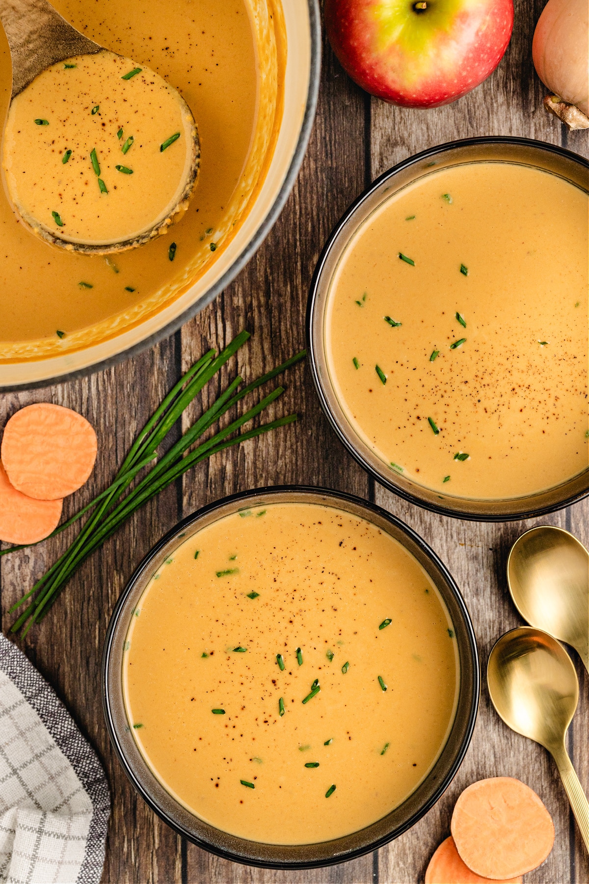 Maple butternut squash apple soup Pot of maple butternut squash and apple soup with bowls alongside