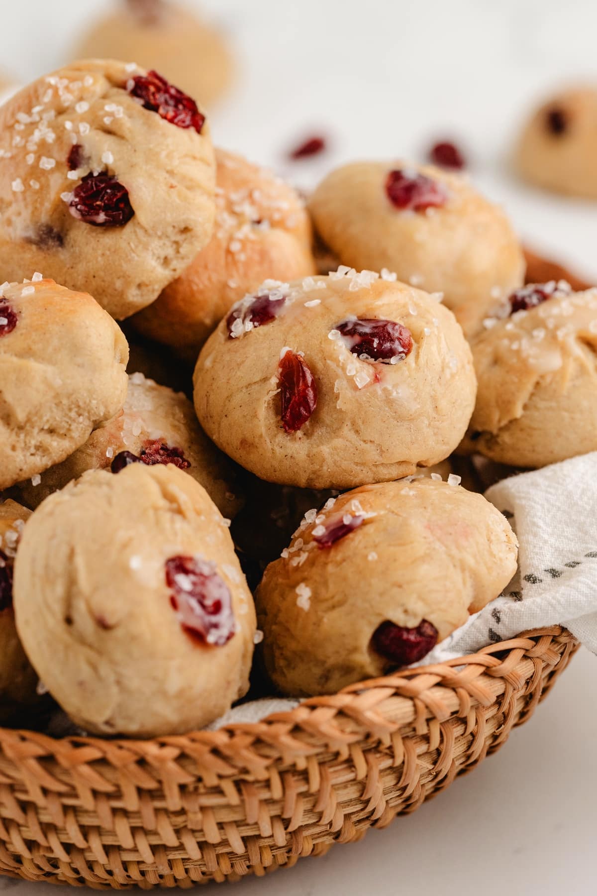 Basket of freshly baked cinnamon-cranberry dinner rolls. Warm cinnamon-cranberry dinner rolls stacked in a basket, ready to serve.