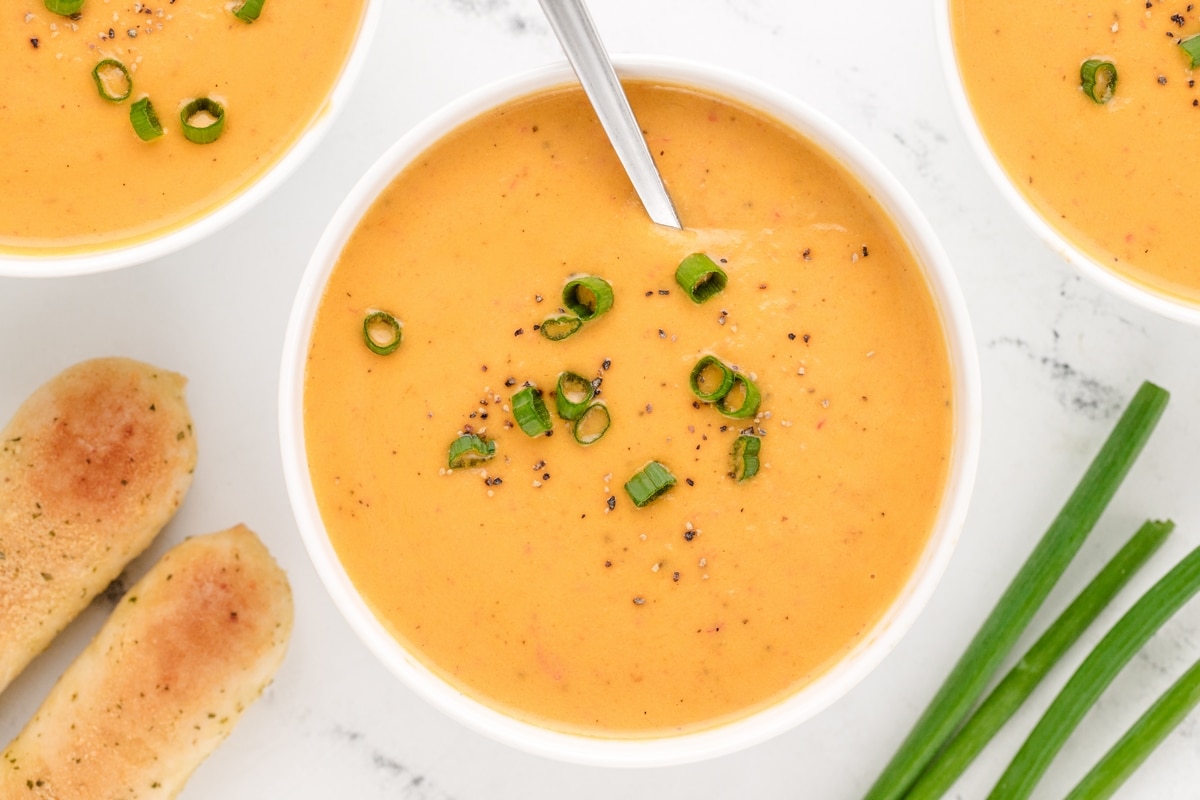Creamy Red Pepper Coconut Soup ready to eat. A comforting, smooth red pepper coconut soup in a rustic bowl, perfect for a cozy dinner.