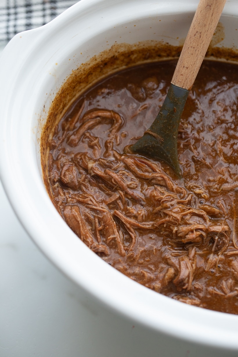 slow cooker chile colorado being stirred